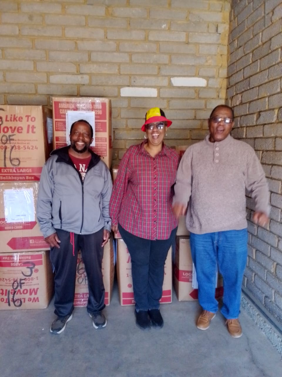 Members of True Vine Tabernacle pose near boxes of clothes